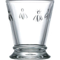 Clear glass tumbler adorned with embossed bee motifs featuring a slightly flared base with a ridged design and a smooth transparent surface