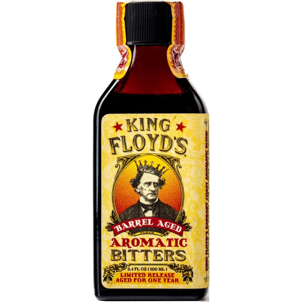 Product photography of a King Floyd's Barrel Aged Aromatic Bitters bottle displaying a vibrant yellow label with "King Floyd's" text flanked by red stars, a regal illustration of a man wearing a crown, and "Limited Release Aged for One Year" in script