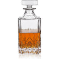 Clear glass decanter filled with amber liquid featuring a faceted square stopper and an intricate diamond-cut pattern on its lower half