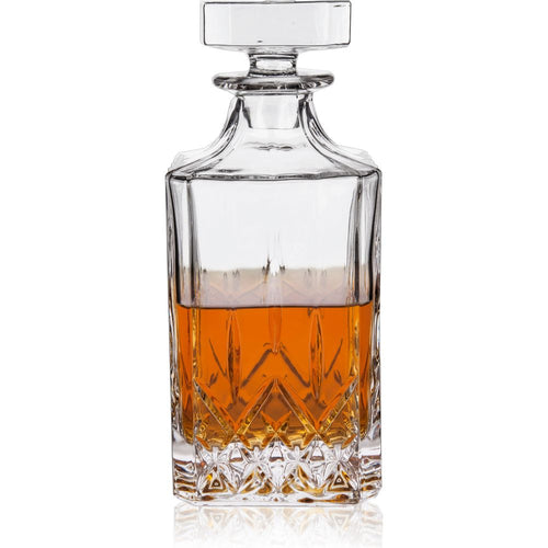 Clear glass decanter filled with amber liquid featuring a faceted square stopper and an intricate diamond-cut pattern on its lower half