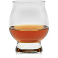 A clear Glencairn glass showcasing its unique bulbous body and thick base, filled with luminous amber-gold whiskey against a stark white background