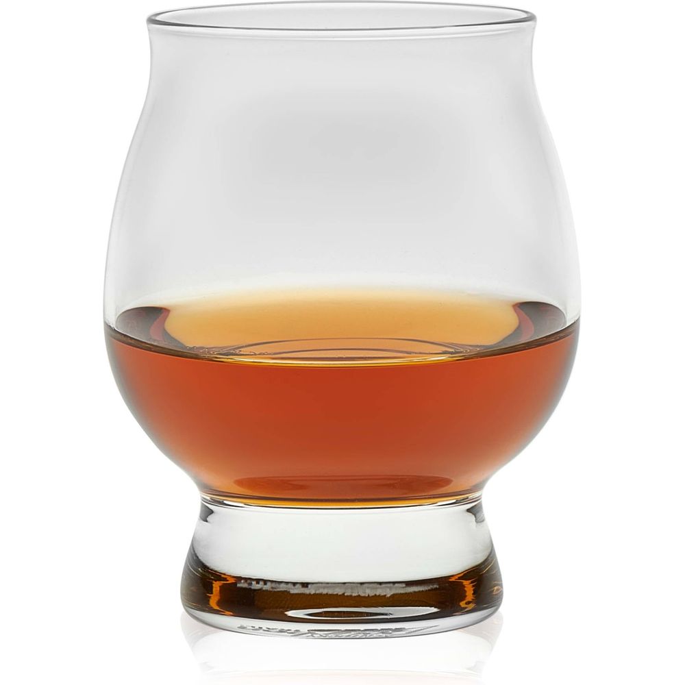 A clear Glencairn glass showcasing its unique bulbous body and thick base, filled with luminous amber-gold whiskey against a stark white background