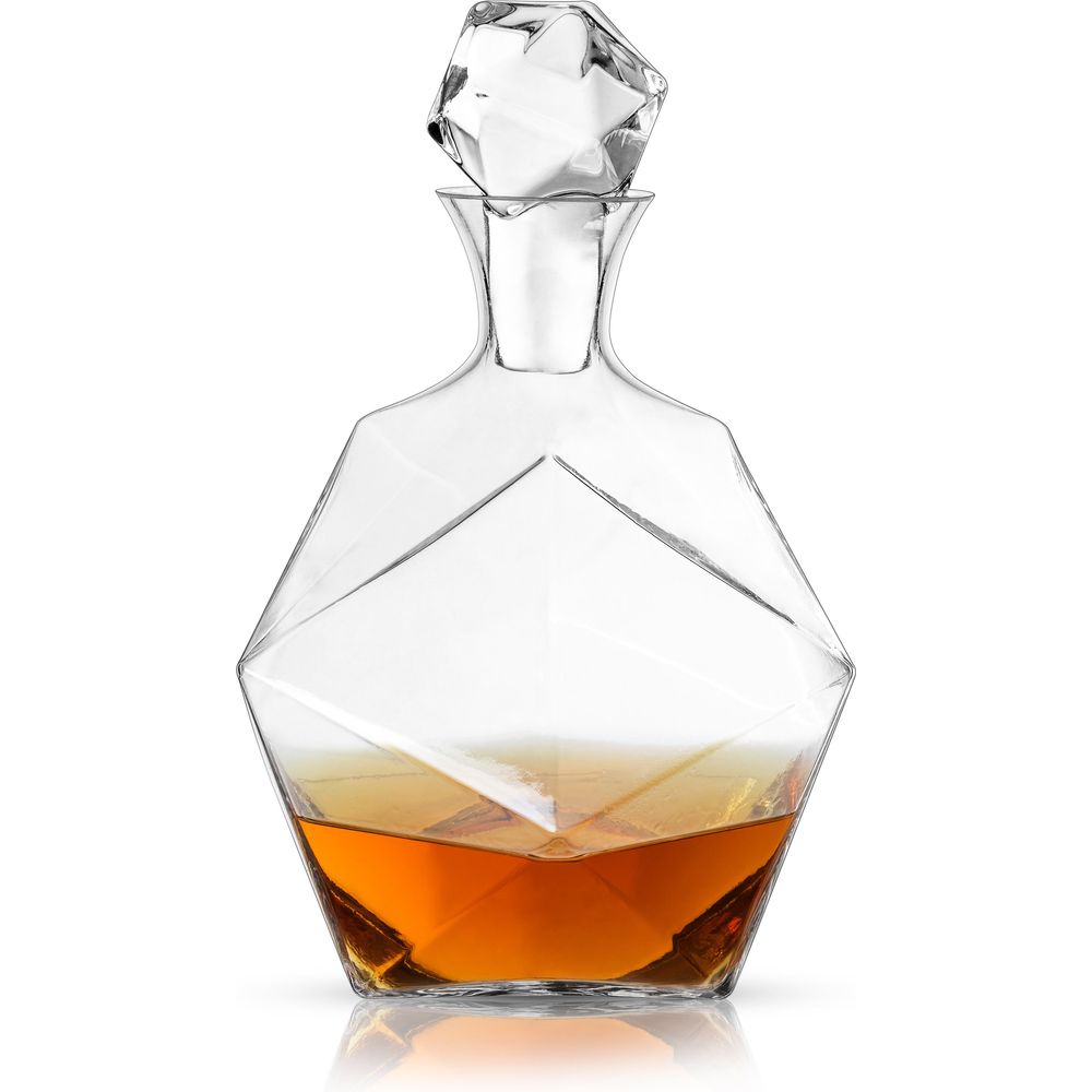 Clear geometric faceted glass decanter with a matching faceted crystal stopper containing warm amber liquid