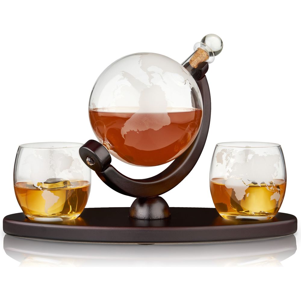 Glass globe decanter set with an etched world map decanter filled with amber whiskey, presented on a dark wooden stand and tray alongside two matching whiskey glasses also featuring world map etchings