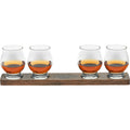 Photograph of four whiskey tasting glasses filled with amber whiskey on a dark wooden flight tray featuring an engraved Kentucky Bourbon Trail logo